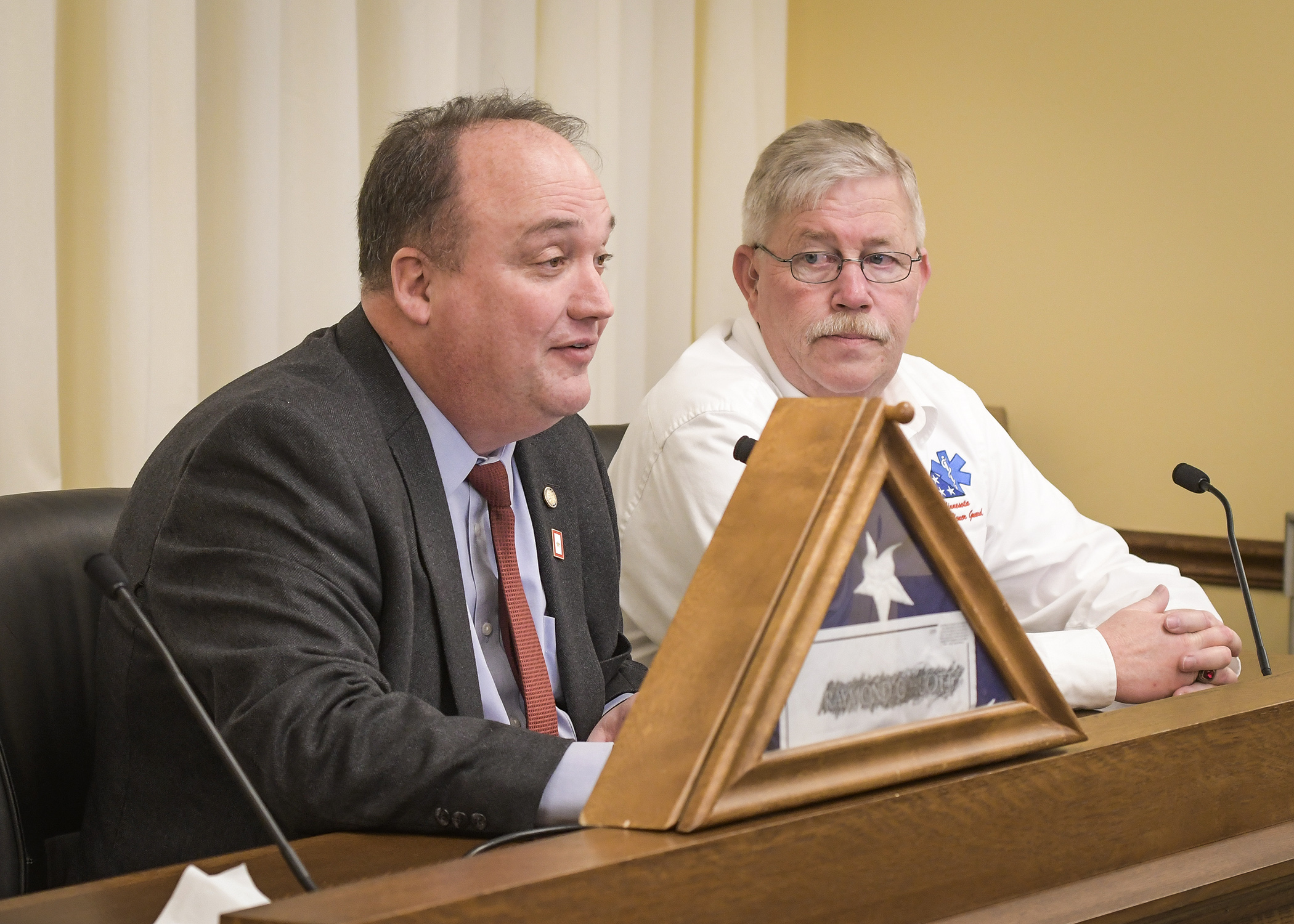 Rep. John Huot, left, and Brad Johnson, executive officer for Minnesota EMS Honor Guard, testify before the House Veterans and Military Affairs Finance and Policy Division March 19. Photo by Andrew VonBank
